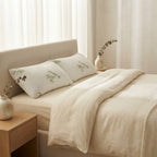 Two bamboo pillows on a made bed with cream linen bedding